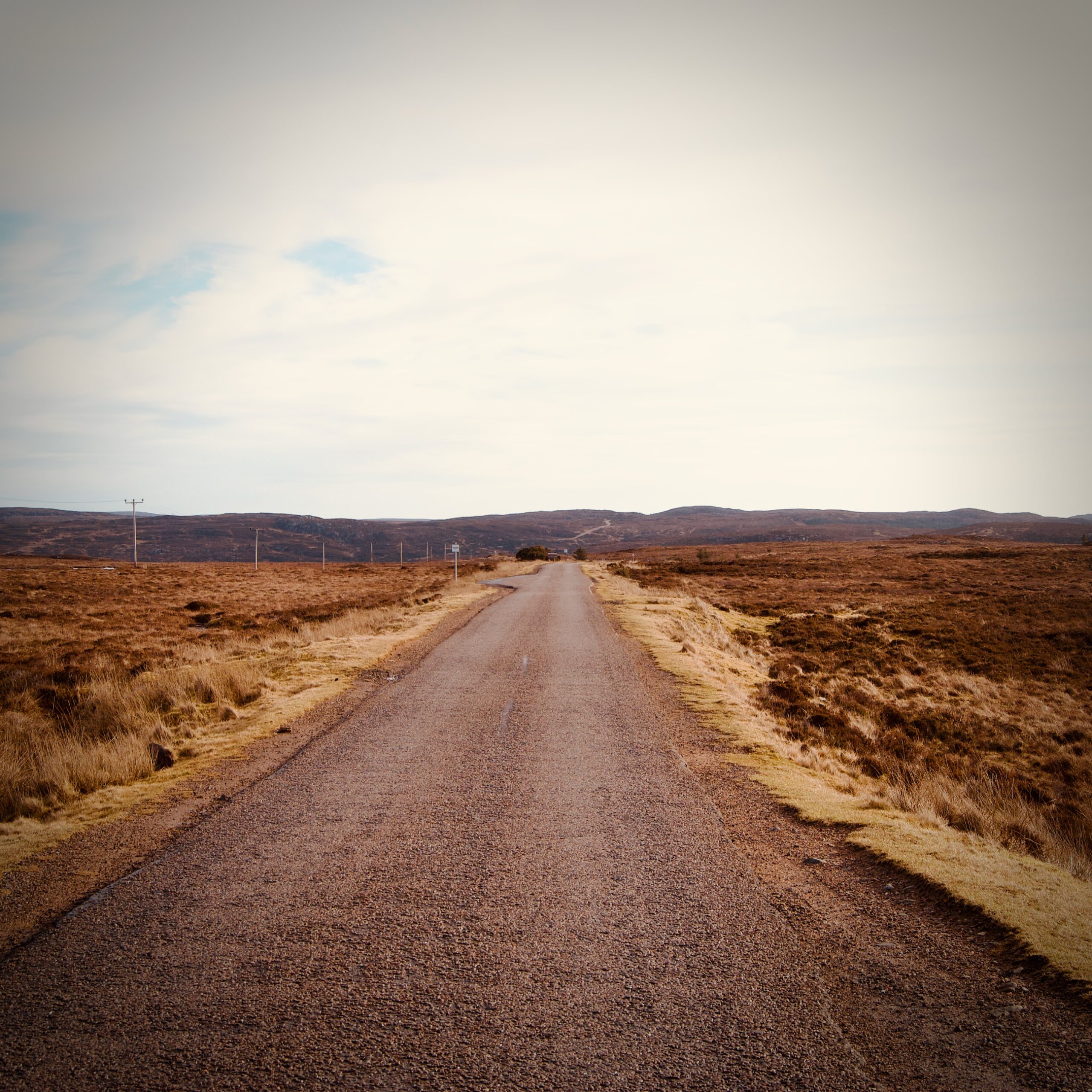 Une route en ligne droite dans un paysage de plateau écossais